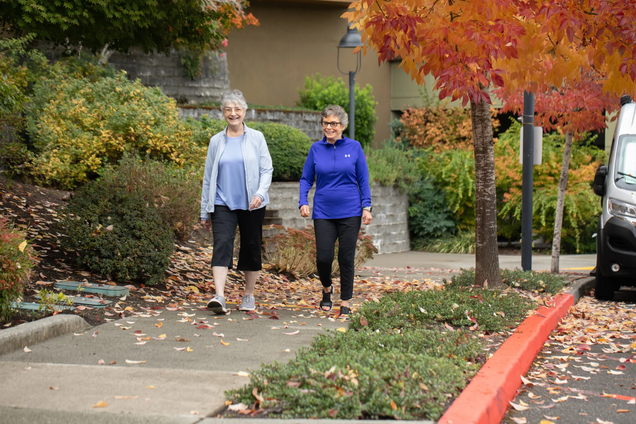 A senior women on a sidewalk outside of Timber Ridge at Talus while discussing how do life plan communities work in Issaquah, WA.