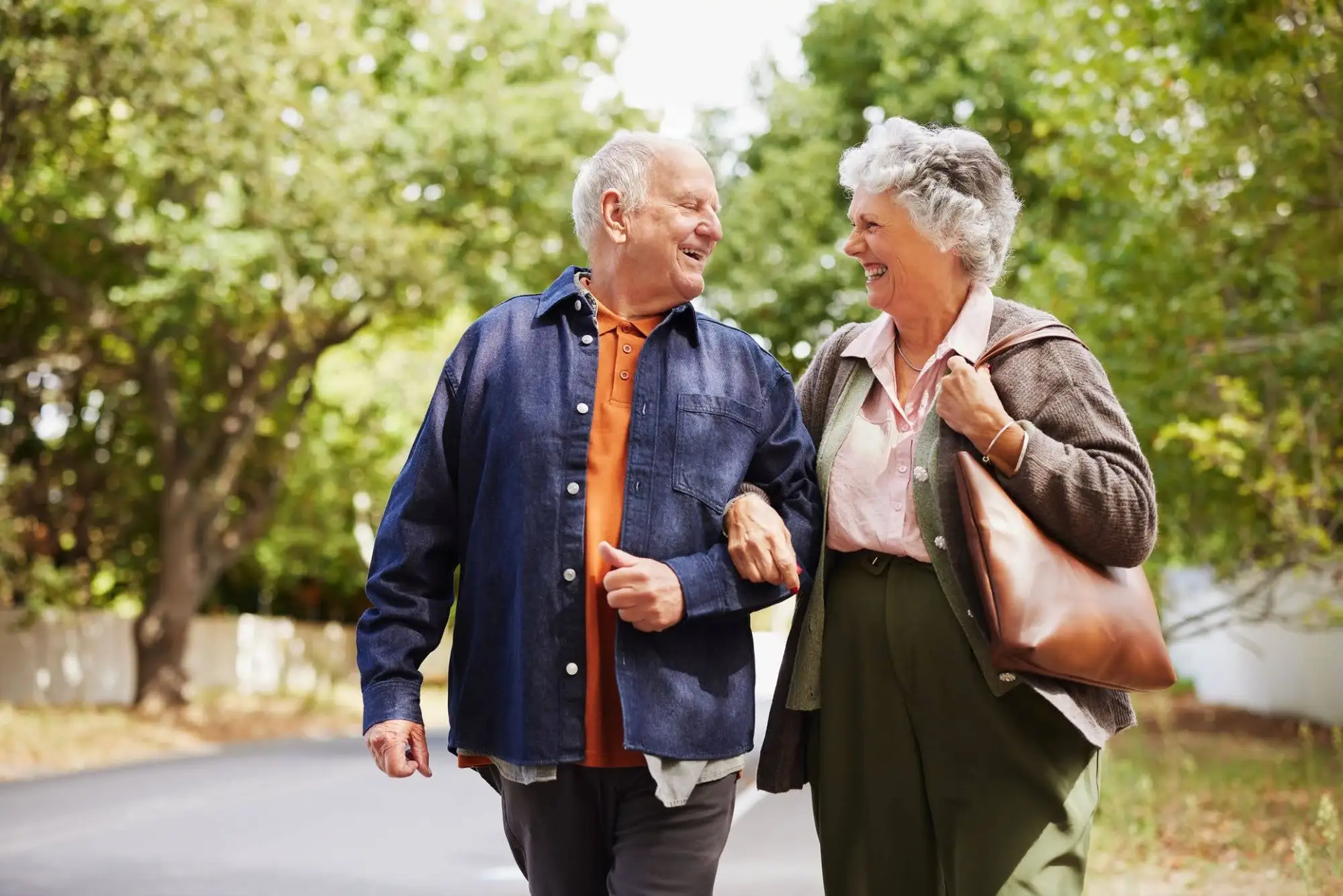 A senior couple walking and talking while walking a nature trail to enjoy active aging at Timber Ridge at Talus in Issaquah, WA.