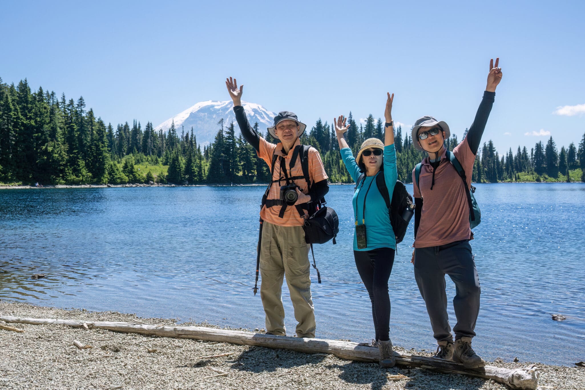 seniors posing for photos by Summit Lake. Mount Rainier in the background. Mount Rainier National Park. Washington State.