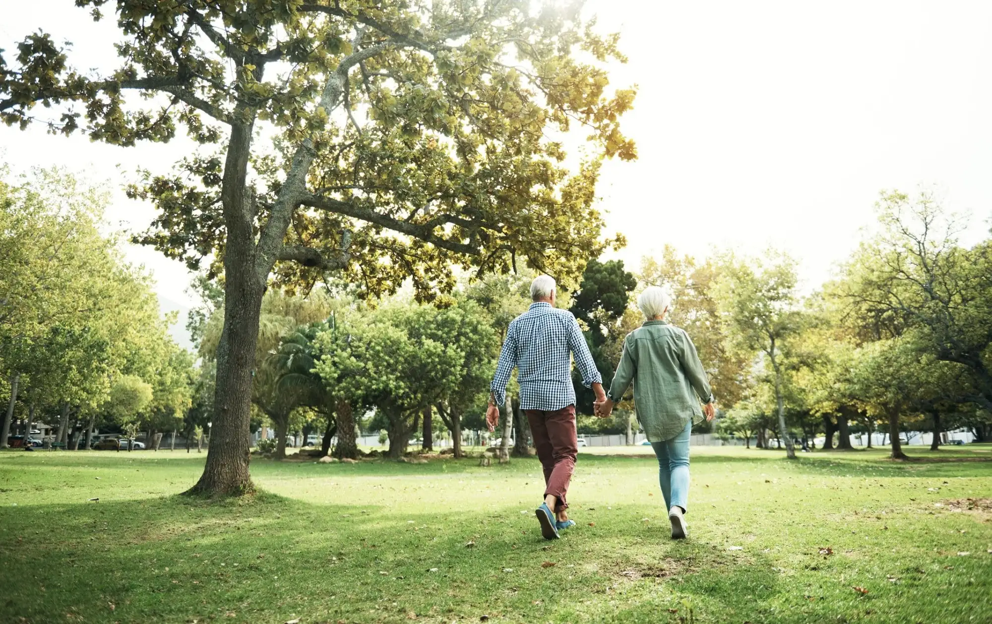 A senior couple enjoying a walking outside of Timber Ridge at Talus which promotes a modern retirement lifestyle full of friendship and freedom in our community.