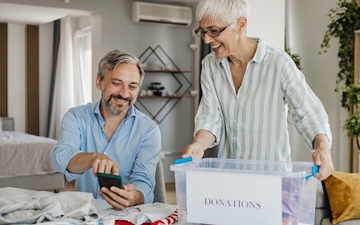 Woman and a man at home, preparing a donation box